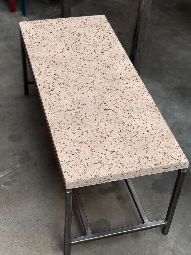 Table basse au plateau en Terrazac, semé d’éclats de montures, sur un piétement en acier.