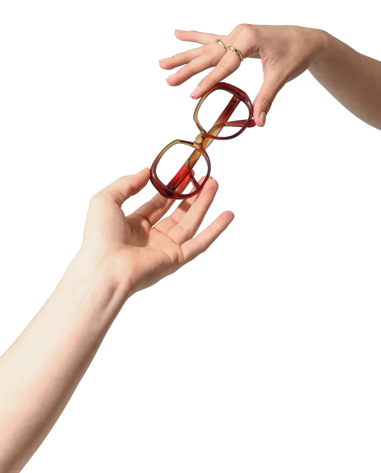 Une main tend une paire de lunettes rouges à une autre.